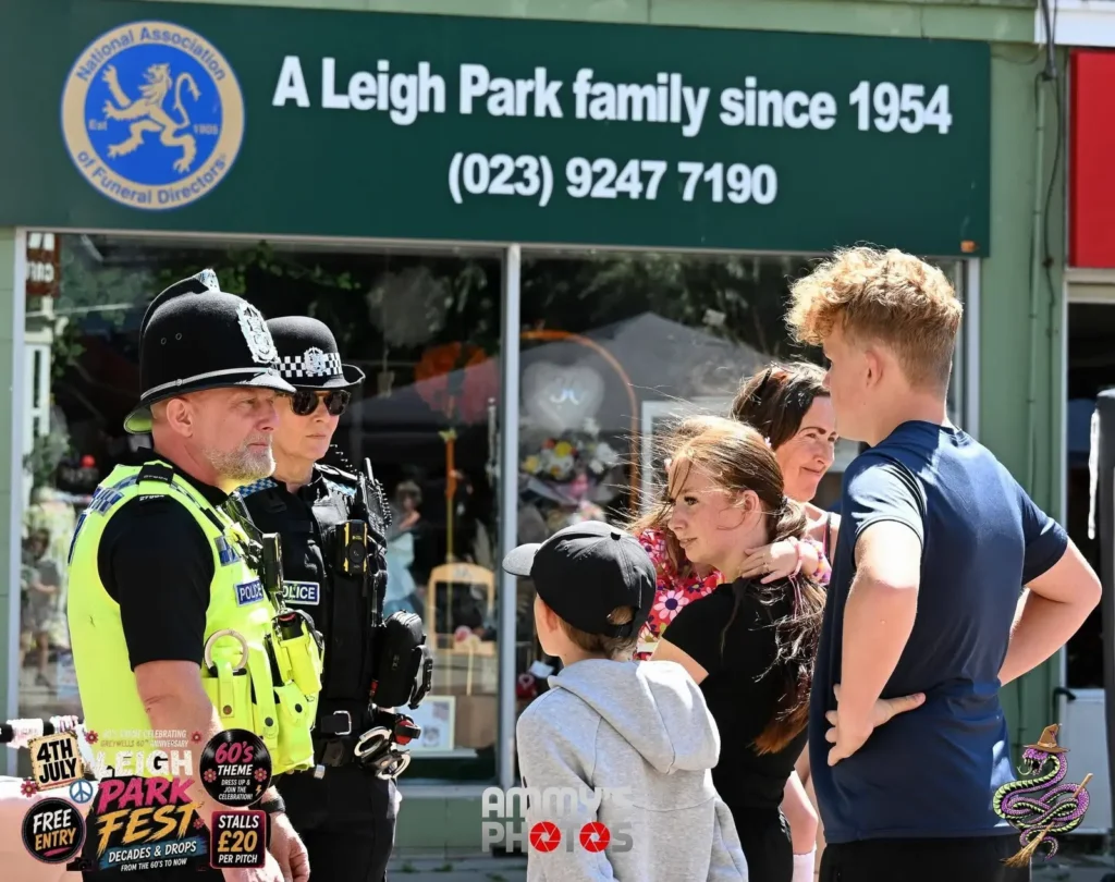 Two police officers talking with a group of festival visitors.